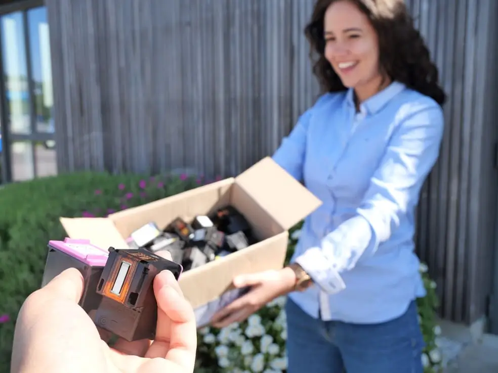 Une personne déposants ses cartouches d'encre vide pour les faire racheter